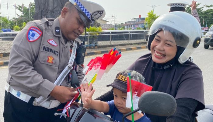 Polres Melawi Bagikan Bendera Kepada Masyarakat Pengguna Jalan